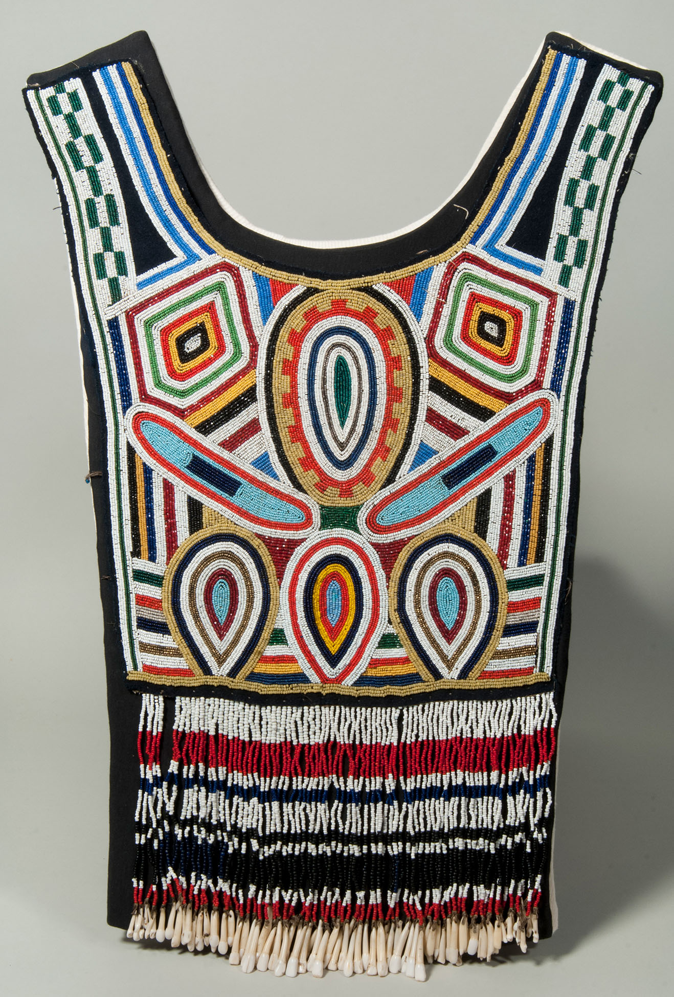 A beaded panel from an Inuit woman's parka, called a Tuilik. The beading pattern centers on concentric ovals with each ring a different colour of beads, including vibrant orange, blue, white, red and black