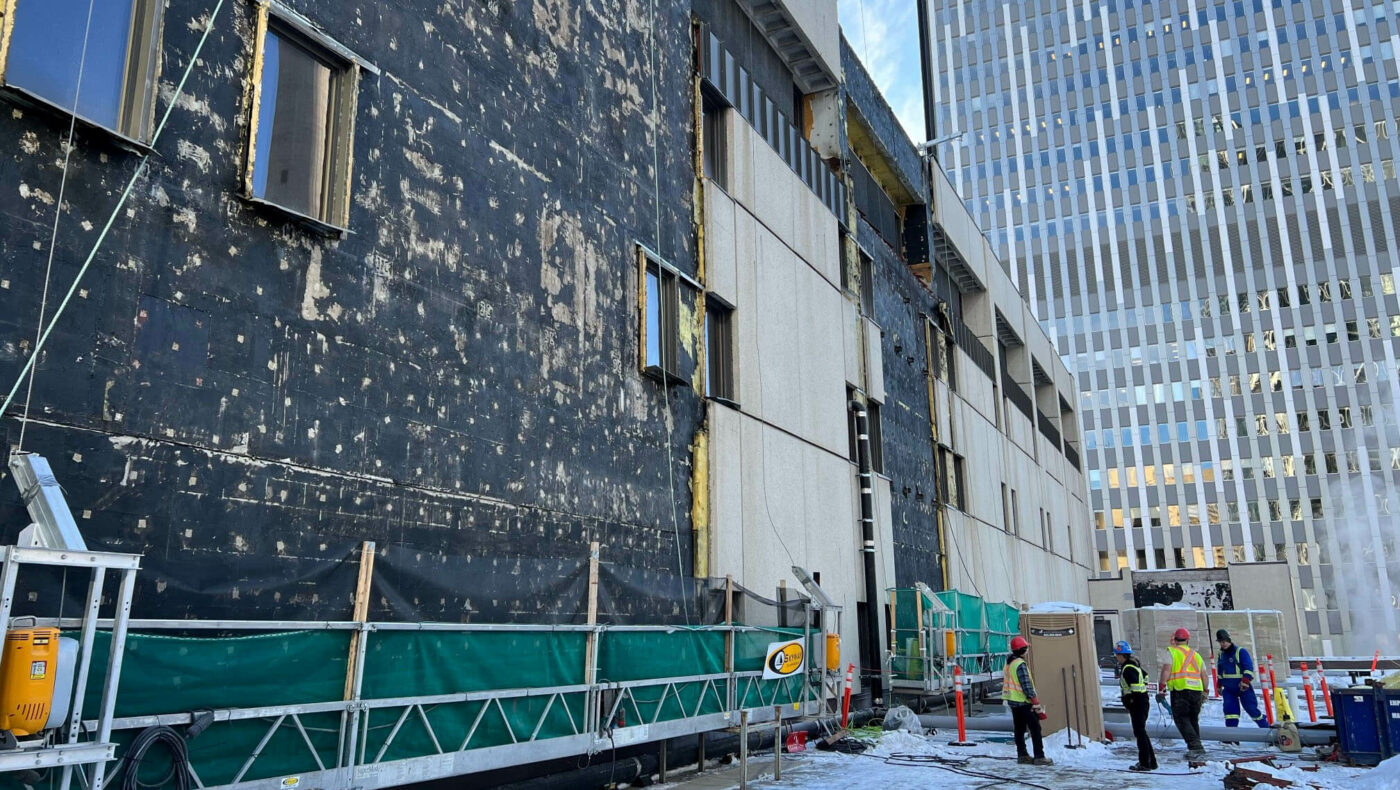 Exterior panels have been removed from Glenbow's building, exposing the original weatherproofing underneath.