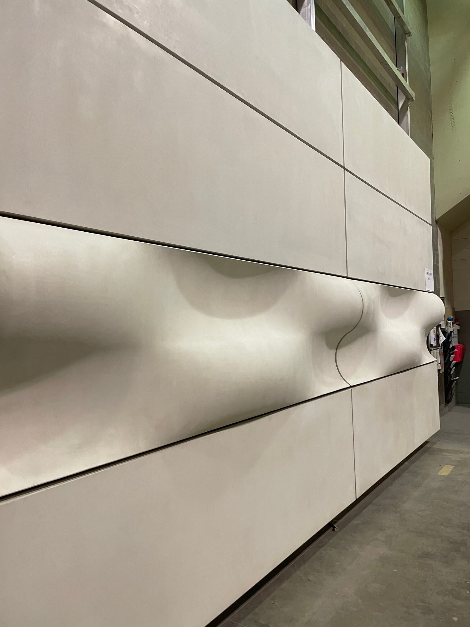 The sample wall showcasing the new building exterior, with wave-like ripples.