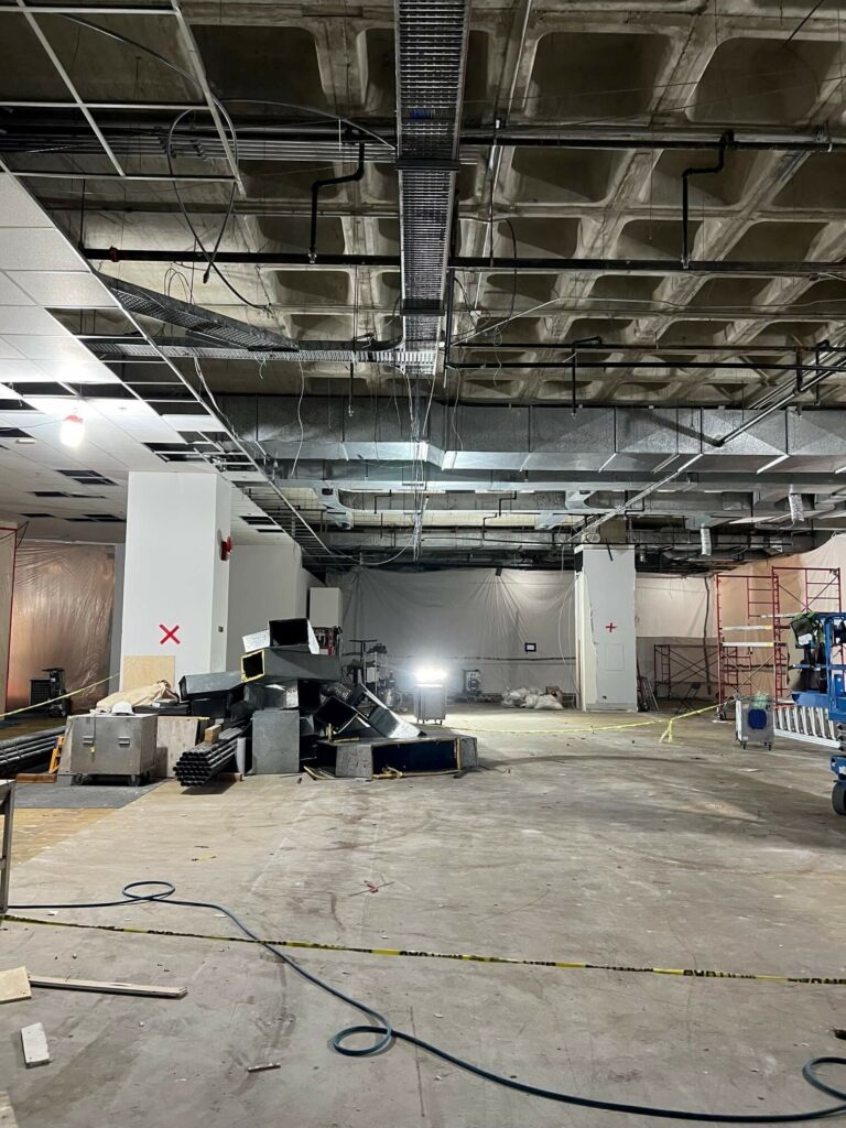 A demolished gallery, exposing the original waffle ceiling and ductwork.
