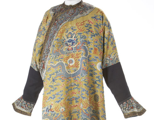 A robe with detailed embroidery in silk and gold-wrapped thread create the image of a dragon. It has five talons on each foot, its body coiling across the fabric.