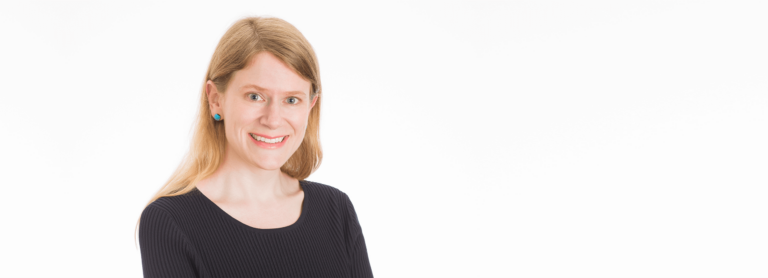 Dr. Jocelyn Anderson smiles in a portrait. She has light-colour, shoulder-length hair and is wearing a dark shirt.